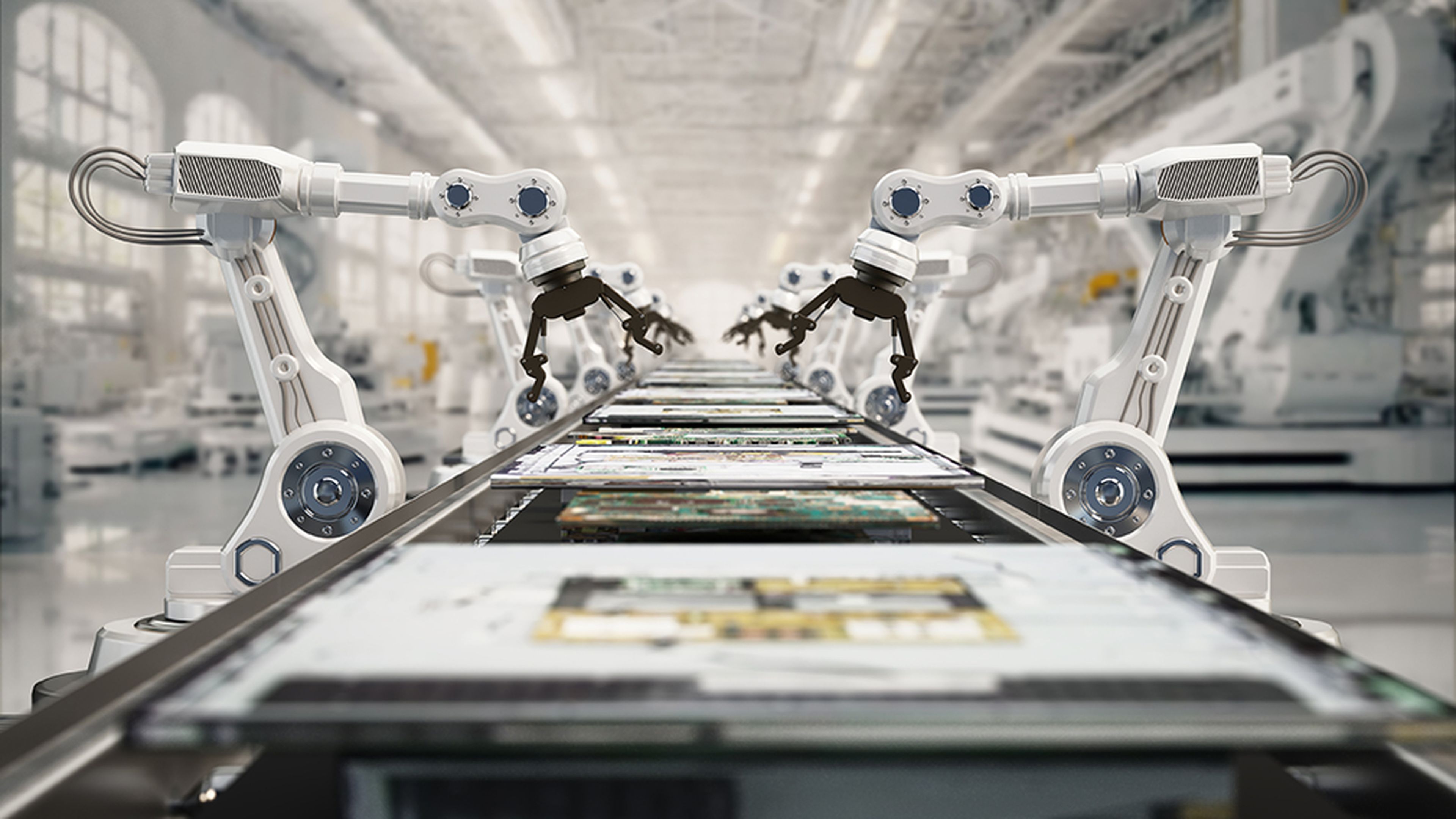Robotic arms assembling electronic components on a conveyor belt in an automated, modern factory setting.